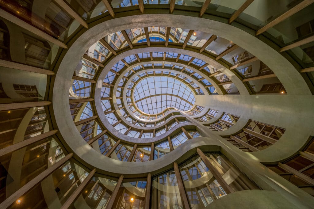Estrutura arquitetonica espiral com claraboia de vidro e formas organicas promovendo a arquitetura sensorial e humana.